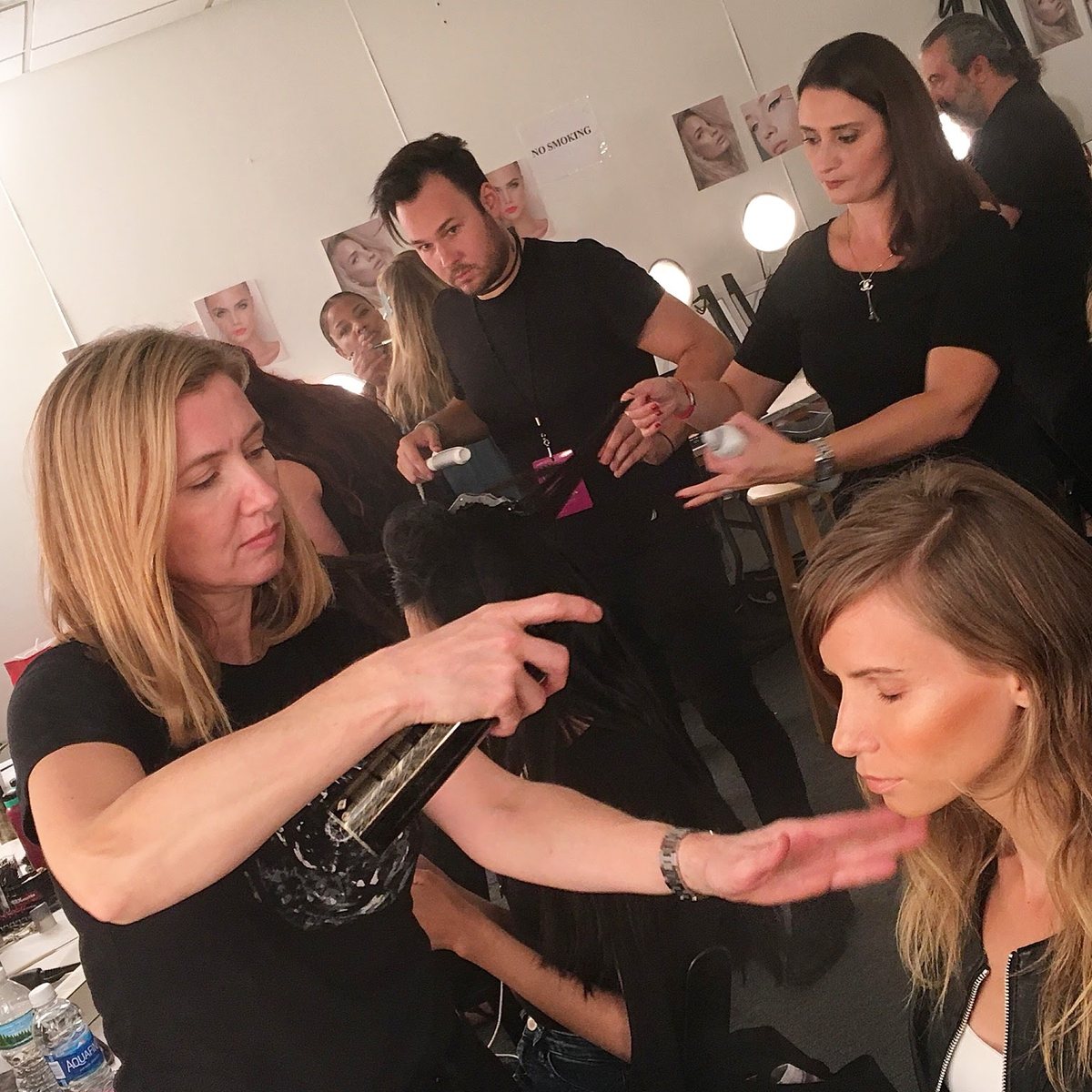 Ayfer Deniz styling a model's hair backstage before a runway show