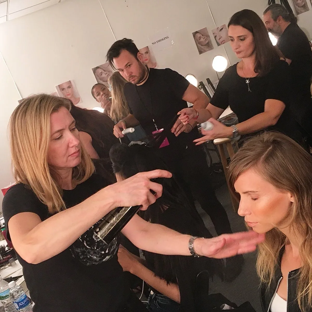 Ayfer Deniz styling a model's hair backstage before a runway show